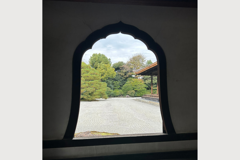 方丈の縁側を窓越しに望む静かな庭の風景